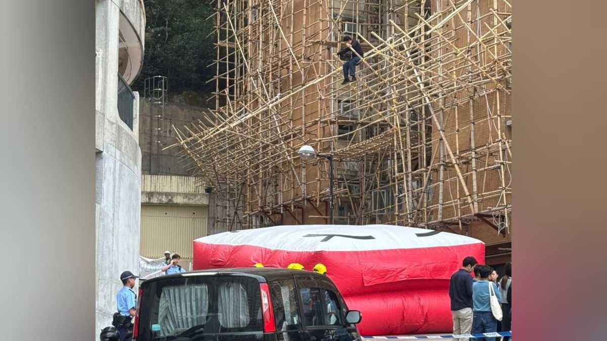 圖：約15名宏業建築工人到碧瑤灣地盤追欠薪　2工人爬上棚架抗議  有工人危坐棚架抗議消防開氣墊戒備
