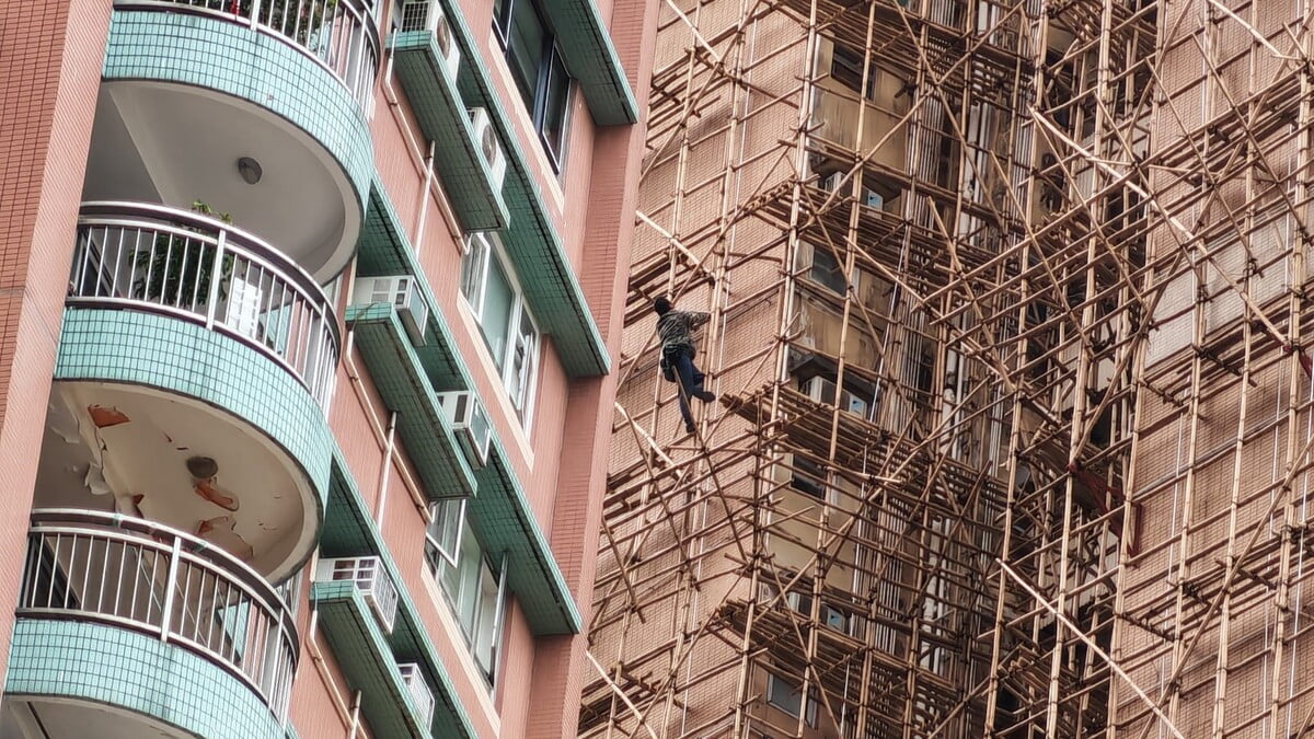 圖：約15名宏業建築工人到碧瑤灣地盤追欠薪　2工人爬上棚架抗議  一名工人爬上棚架抗議宏業建築拖欠工資